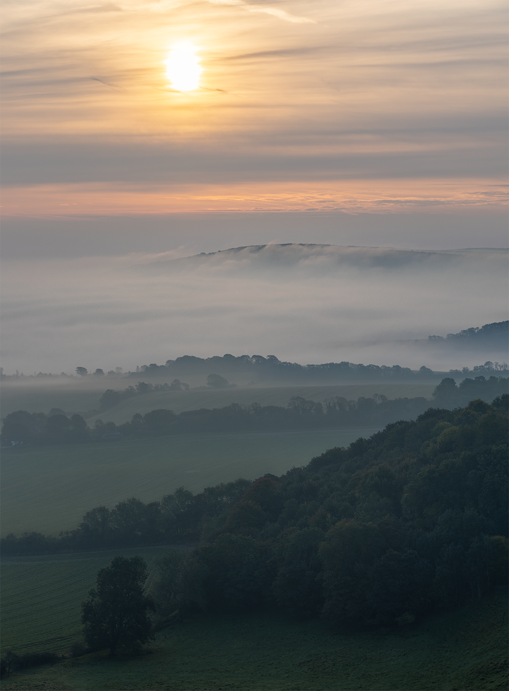 Photogrphic print of an ethereal sunrise over an early morning mist inversion flowing over the South Downs.