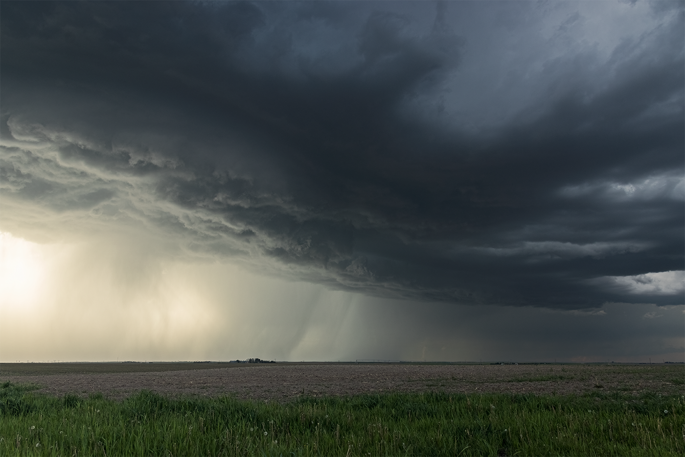 Photographic print of the enormous base of a supercell thunderstorm dwarfing the farmstead over which it passes in Arthur Country, Nebraska.