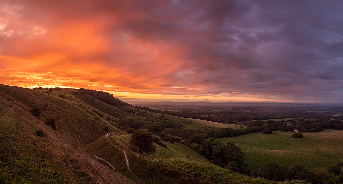 Ditchling Beacon in the heart of the South Downs sits beneath a firey sunset of virga.