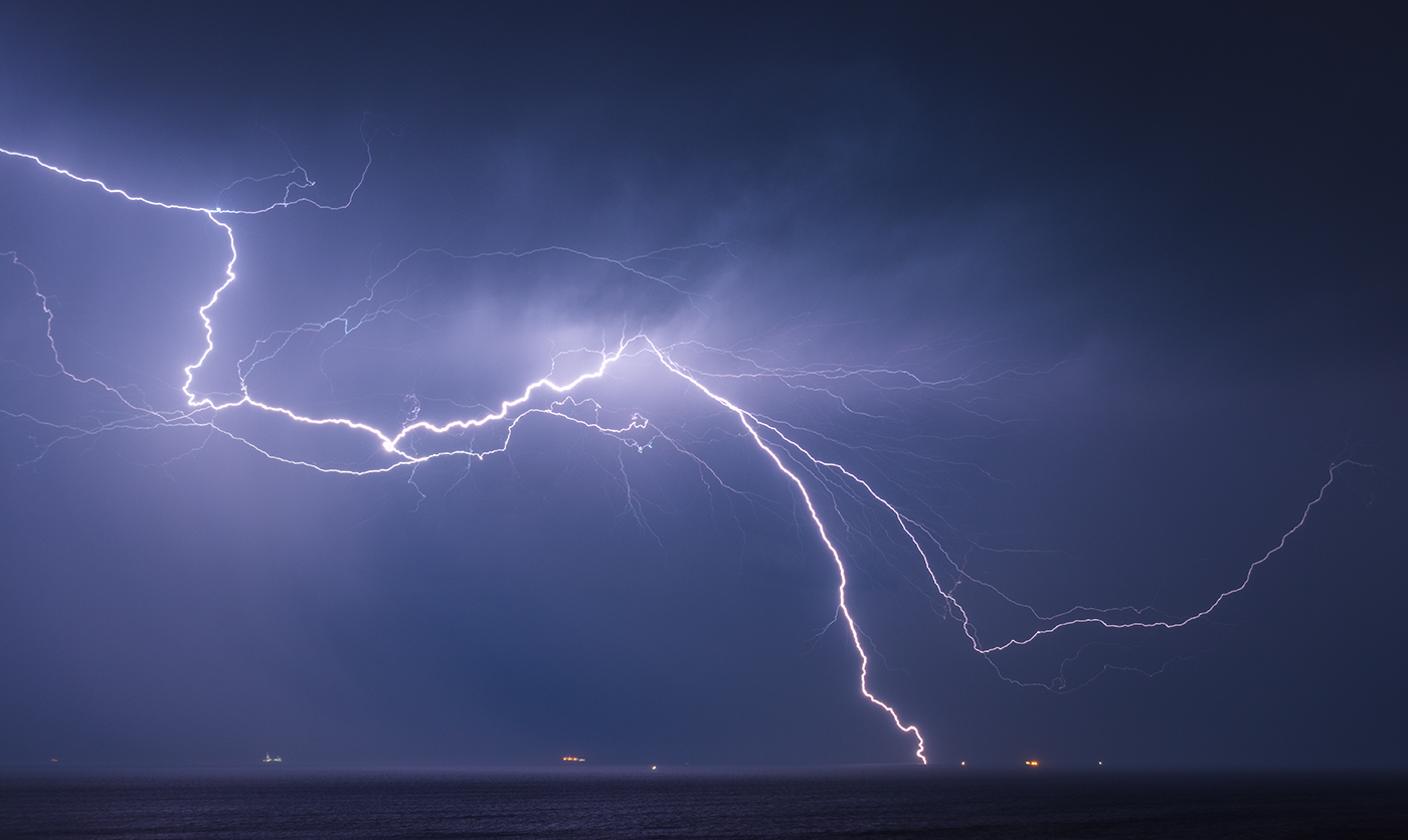 An impressive forked lightning bolt with many branches at night over the English Channel.