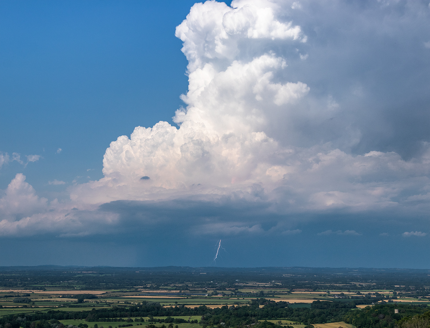 Lightning strikes from the base of a tall cumulonimbus cloud in southern england on a hot summer's afternoon.