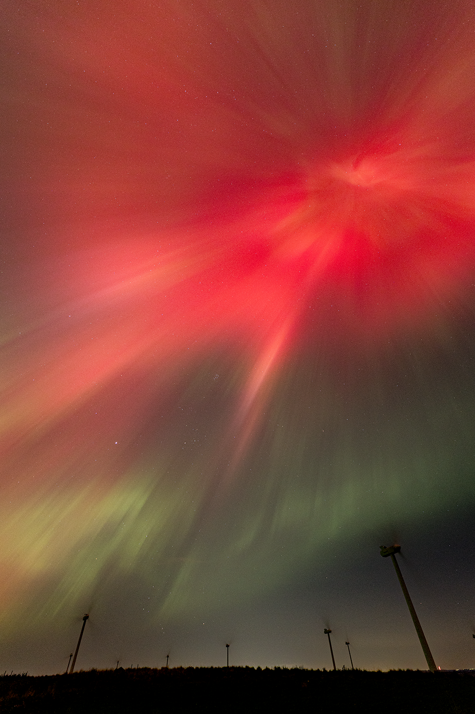 The celestial flare of an aurora corona beams riotously overhead.