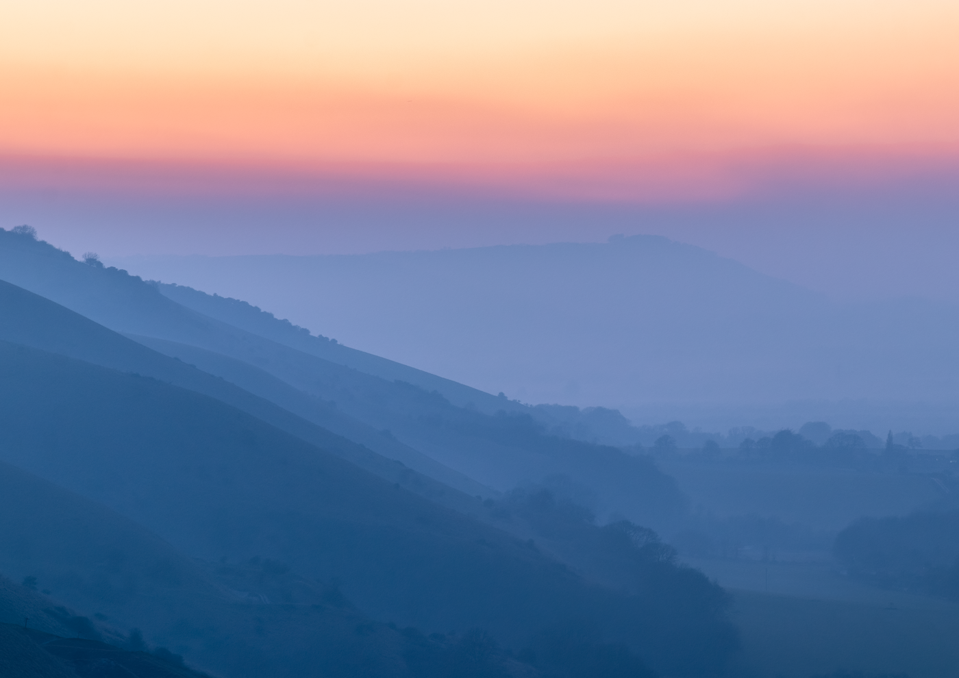 Misty landscape with layers of hills fading into the distance.