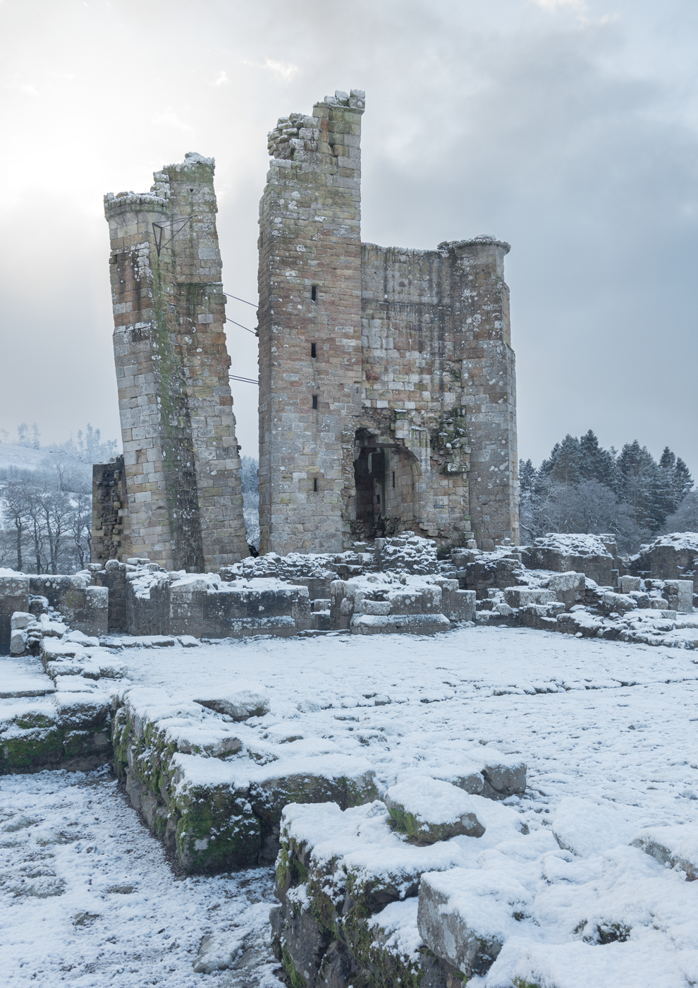 Winter landscape with snow covering the ruins of Edlingham Castle.