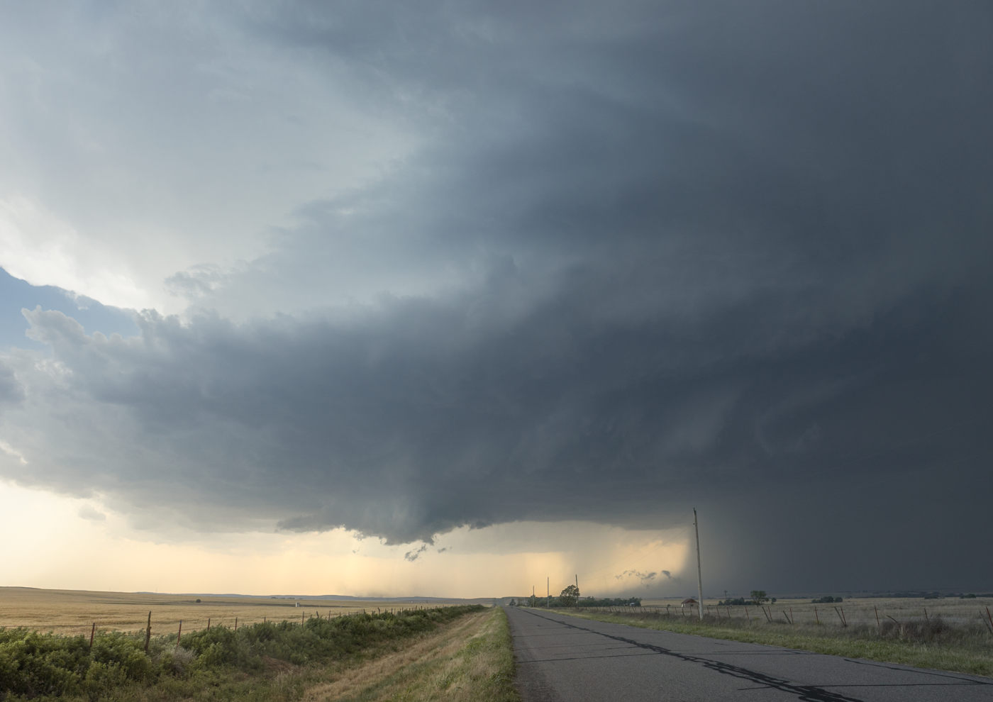 Massive supercell storm cloud with swirling formations over a flat plain.